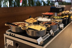 A buffet with various food items including meats, cheeses, and vegetables.