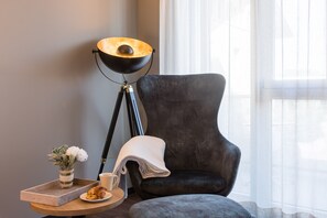Relax in a serene space with a comfortable armchair, floor lamp, and beautiful flowers.
