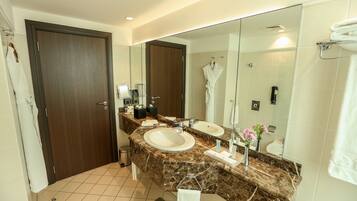 A bathroom with two sinks, a large mirror, and a towel rack.