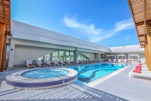 Una piscina al aire libre, camas de piscina gratis, sombrillas