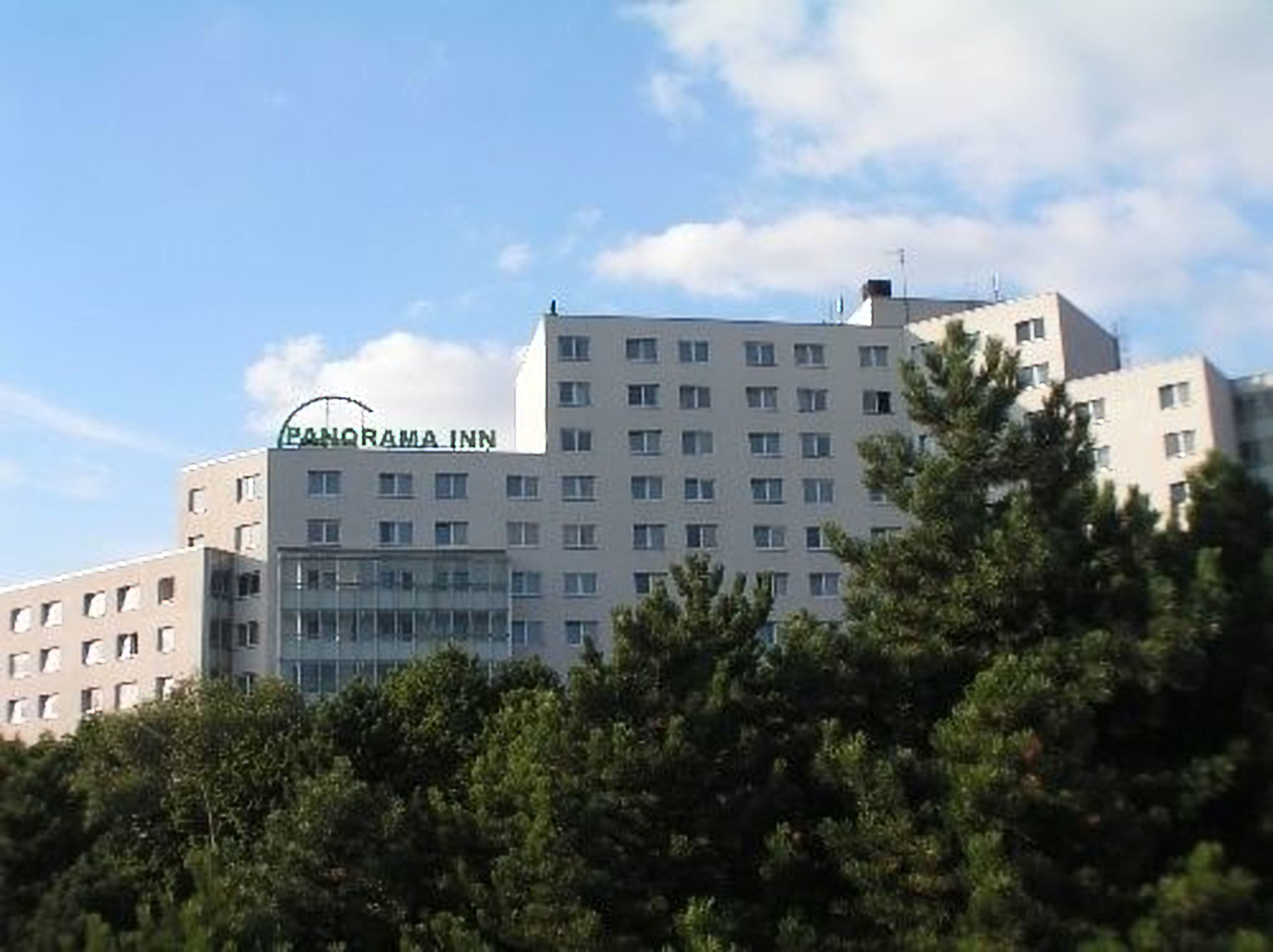 Un hotel de varios pisos con el nombre "Panorama Inn" en la fachada.