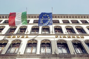 Rakennuksessa on kyltti, jossa lukee ”HOTEL FIRENZE”, ja sen edessä on kaksi lippua: Italian lippu ja Euroopan unionin lippu.