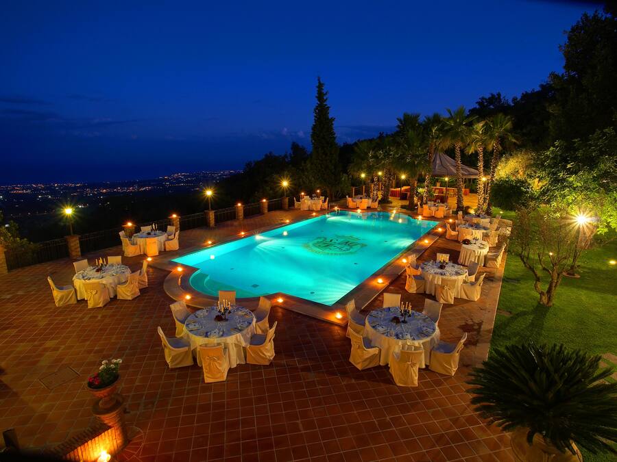 Una piscina techada, una piscina al aire libre, sombrillas