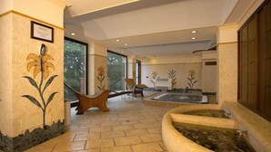 A spa area with a hot tub, a wooden bench, and a wall-mounted phone. - Airone Wellness Hotel (Zafferana Etnea)