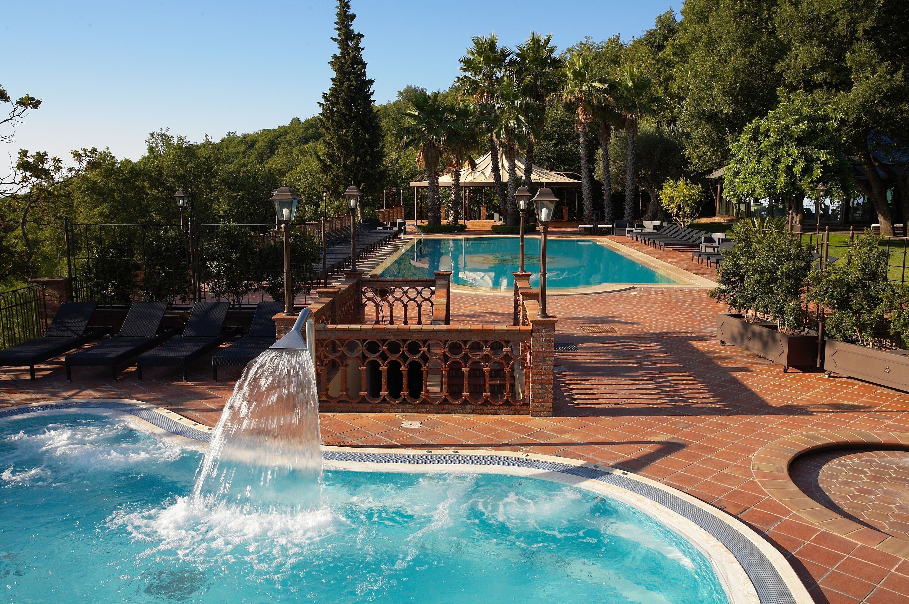 Una piscina cubierta, una piscina al aire libre, sombrillas