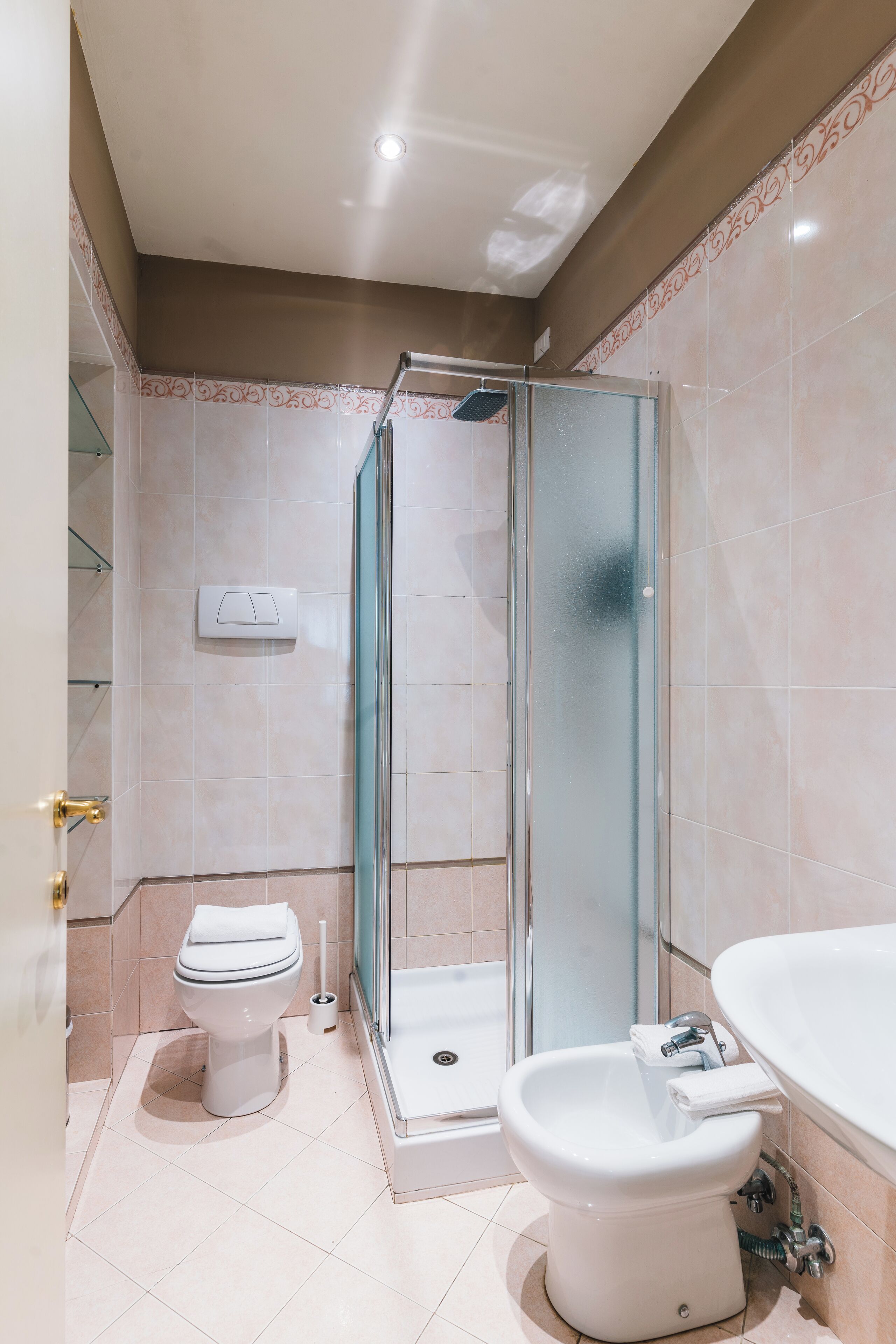 Une salle de bain comprenant des toilettes, un bidet, une douche et un lavabo.