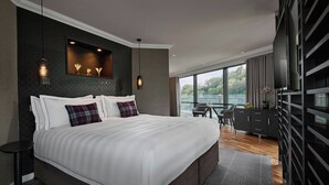 A modern hotel room with a large bed, a desk, and a view of the outdoors. - The Glasshouse, Autograph Collection (Edinburgh)