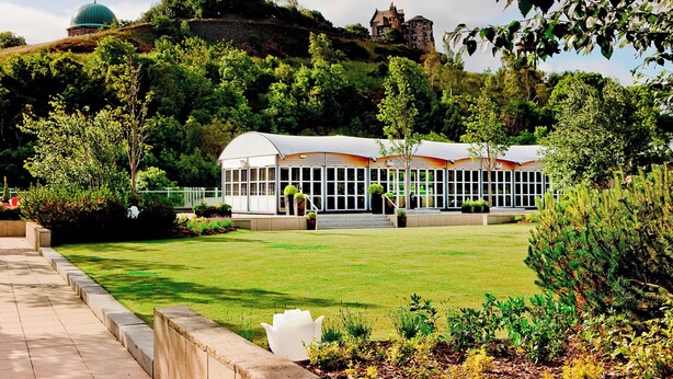 A building with a dome and a castle-like structure on a hill. - The Glasshouse, Autograph Collection (Edinburgh)