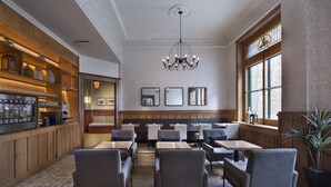 A restaurant with wooden paneling, a chandelier, and a seating area with tables and chairs. - Auberge Saint-Pierre (Québec City)