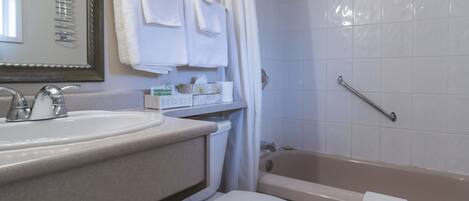Un baño con lavamanos, espejo y bañera.