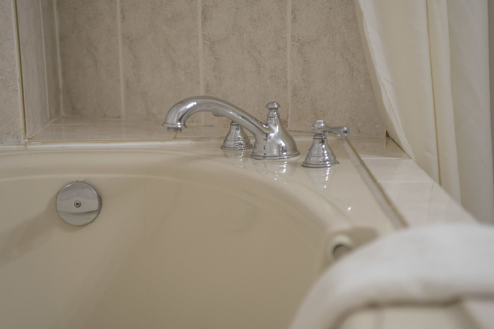 Un baño con una bañera, un solo grifo y un cabezal de ducha.