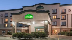 Entrada de hotel con un letrero verde que dice "Wingate by Wyndham".