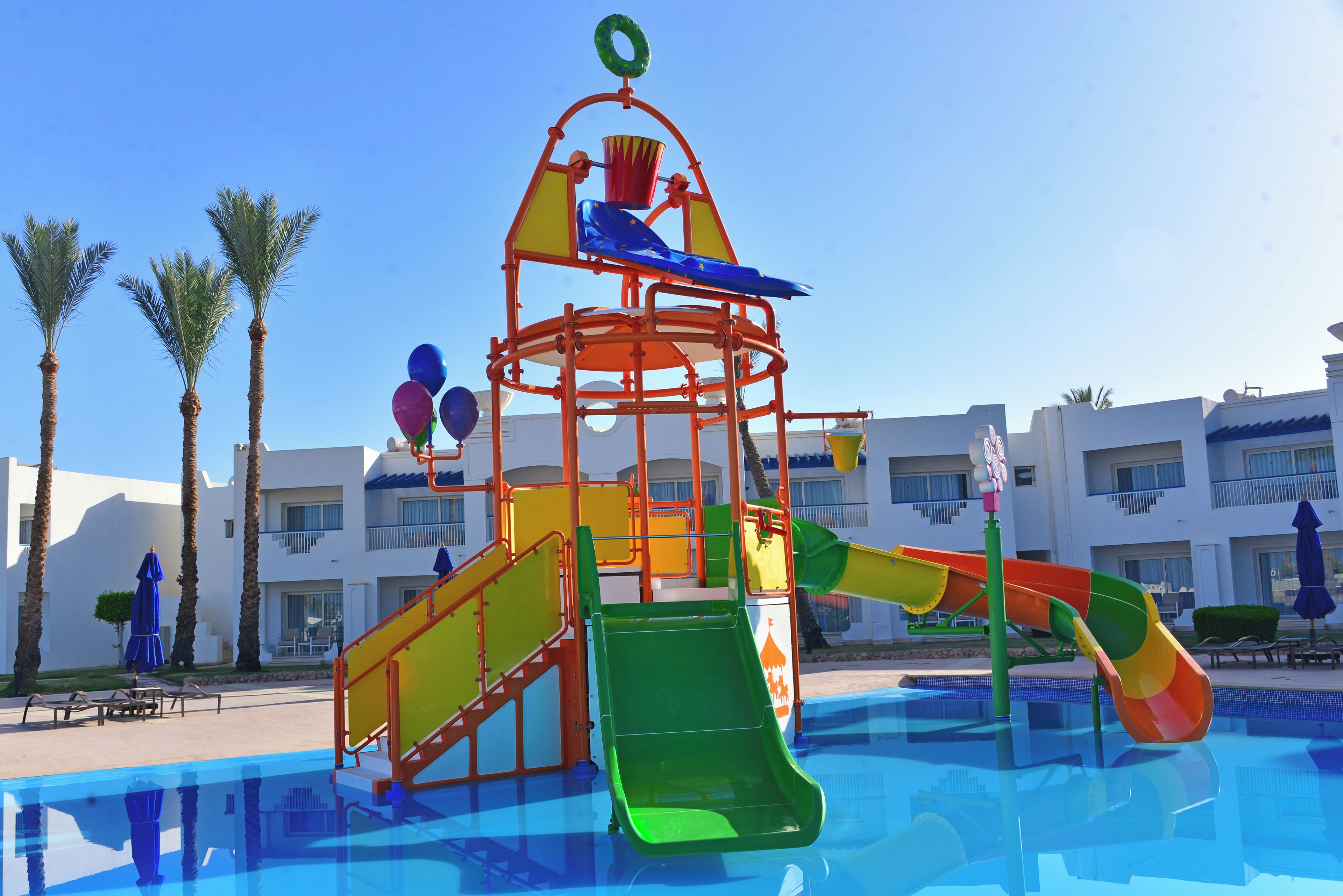 Un parc aquatique avec un toboggan multicolore et une piscine.