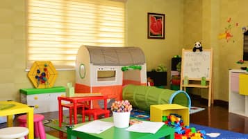 Children can play and explore in this spacious room with a playhouse, table, chairs, and play mat.