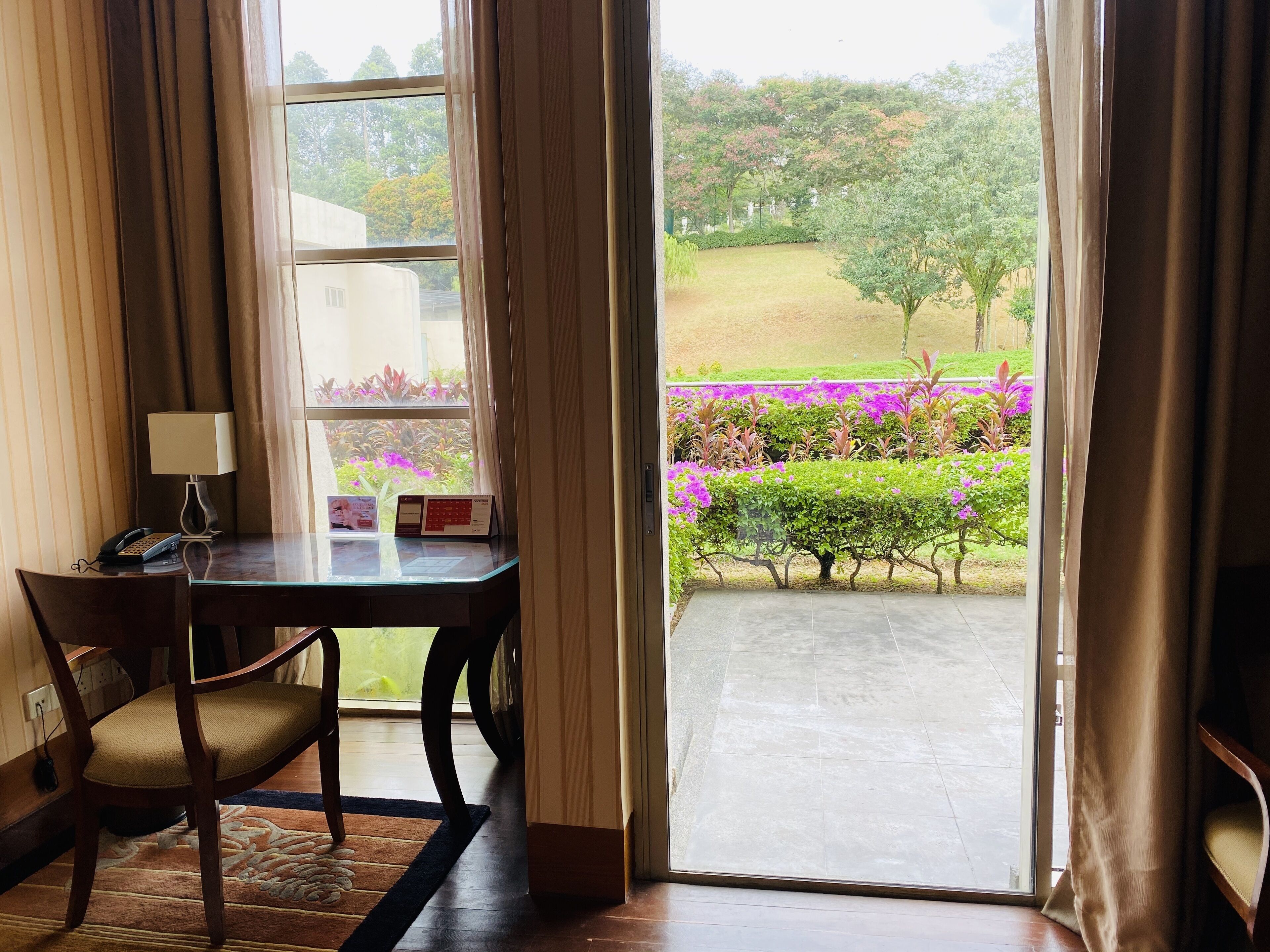 A room with a table, chair, and a window with curtains.