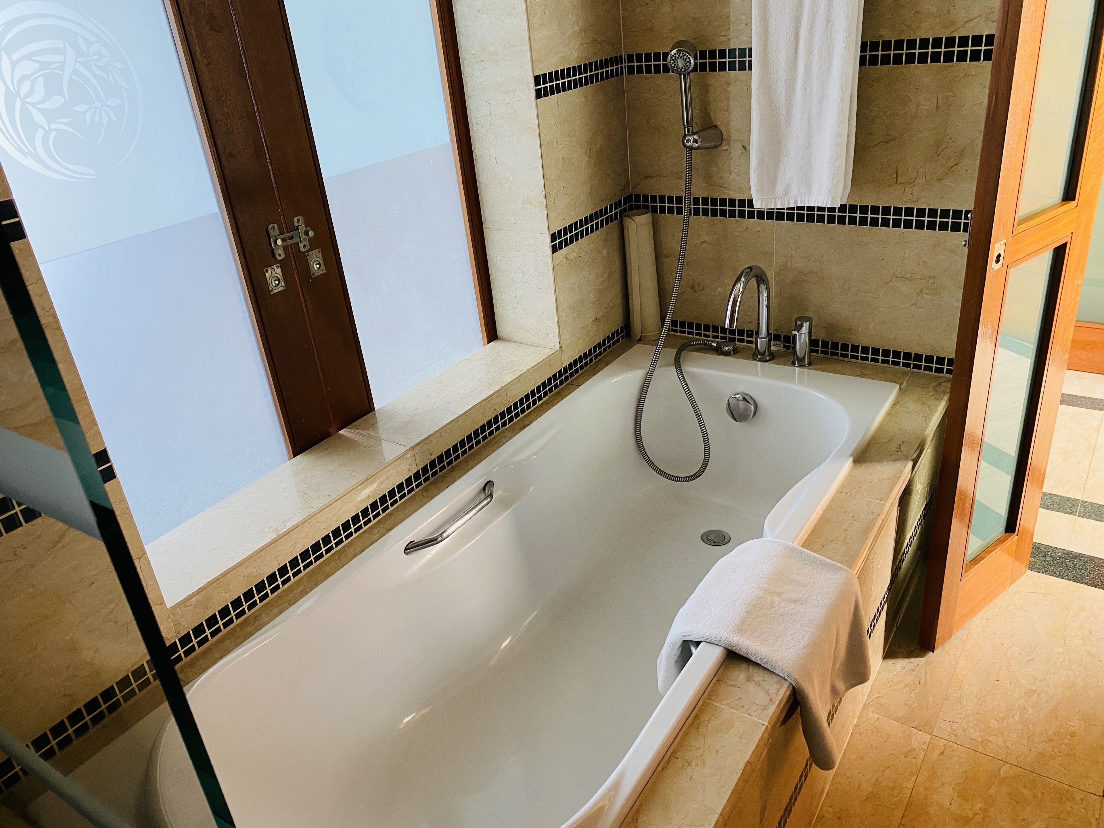 A bathroom with a large bathtub, a shower, and a sink.