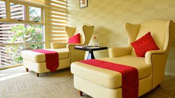 Ein Zimmer mit zwei cremefarbenen Sofas und einem kleinen Tisch, jeweils mit einer roten Decke.