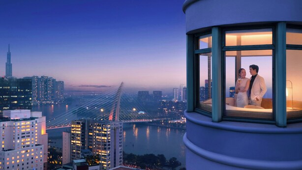 A high-rise building with a panoramic view of a cityscape, including a prominent bridge and skyscrapers.