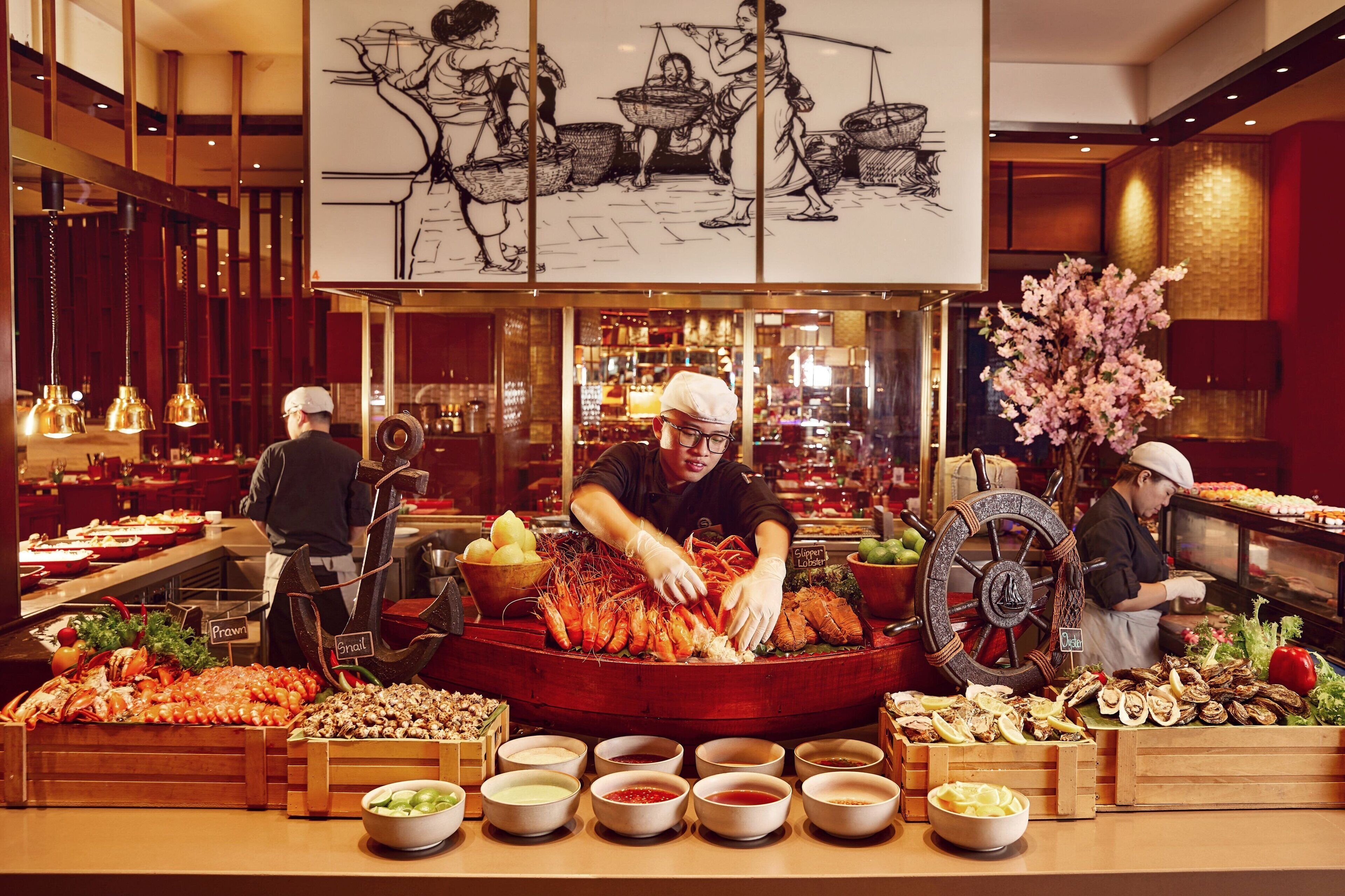 A buffet with seafood, including prawns and oysters, and various sauces.