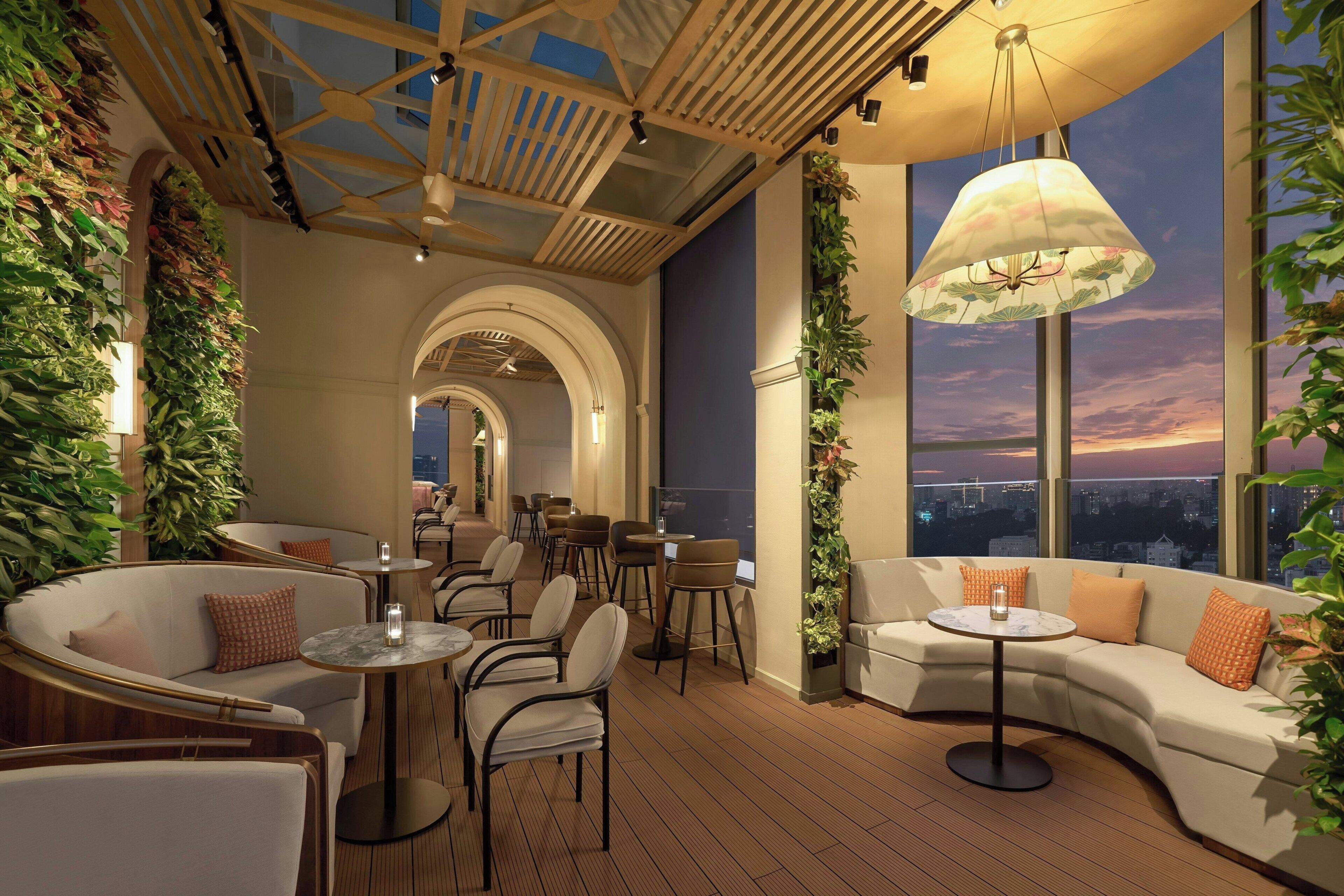 A modern interior with seating areas, tables, and a large window with a city view.