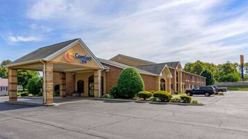 A Comfort Inn hotel with a brick facade, a covered entrance, and a parking lot.
