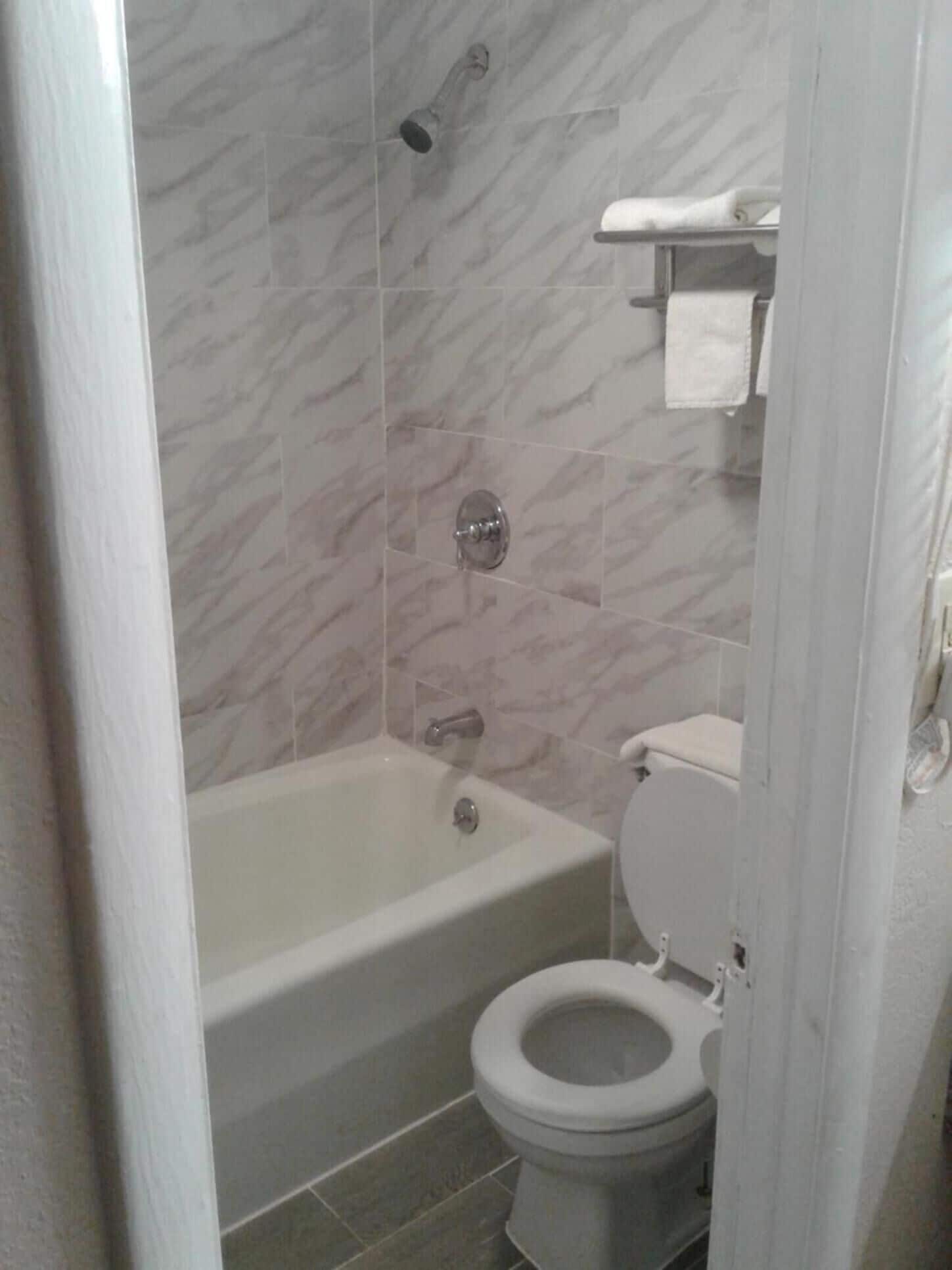 Un baño con bañera, inodoro y ducha.