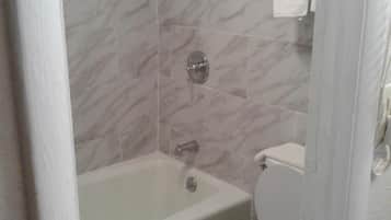 A bathroom with a bathtub, toilet, and shower.