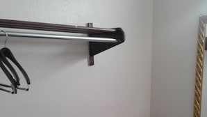 A bathroom with a granite countertop, a towel rack, and a mirror with a decorative frame. - Budget Inn Express (Anderson)