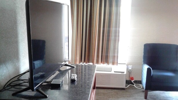 A hotel room with a desk, a computer, a chair, a bed, and a window with curtains. - Budget Inn Express (Anderson)