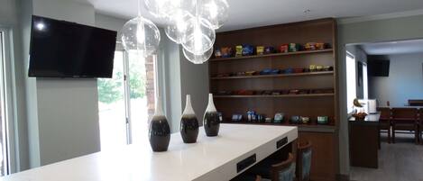 A modern kitchen with a central island, a built-in oven, and a dining area with wooden chairs.
