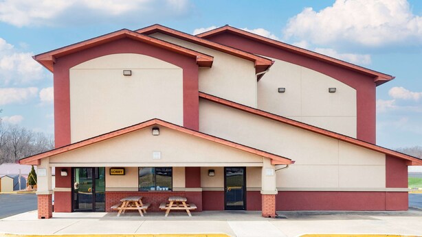 A two-story building with a beige and red facade, a covered entrance with picnic tables, and a 'Lobby' sign. - Super 8 by Wyndham Waynesburg (Waynesburg)