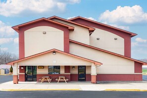 A two-story building with a beige and red facade, a covered entrance with picnic tables, and a 'Lobby' sign. - Super 8 by Wyndham Waynesburg (Waynesburg)