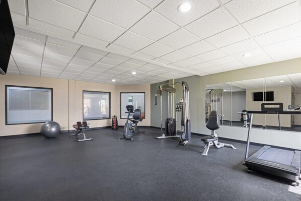 A gym with exercise equipment, a treadmill, and a mirrored wall. - Wingate by Wyndham Augusta/Fort Eisenhower (Augusta)