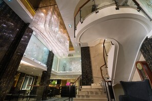 A grand lobby with a chandelier, marble columns, a staircase, and a reception desk. - Empress Hotel HoChiMinh City (Ho Chi Minh City)