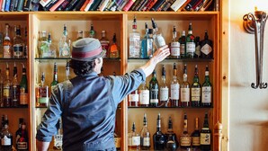 A bar area with a wooden bookshelf filled with books and liquor bottles. - The Inn at Solitude (Solitude)