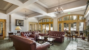 A spacious lobby with leather sofas, a chandelier, and large windows. - The Inn at Solitude (Solitude)