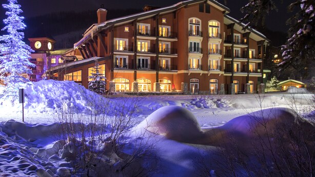 A multi-story hotel with balconies and a clock tower. - The Inn at Solitude (Solitude)