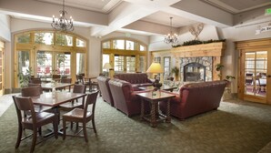 A spacious lobby with high ceilings, large windows, and a fireplace. There are multiple seating areas including a sofa and chairs. - The Inn at Solitude (Solitude)