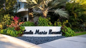 A sign for Santa Maria Resort surrounded by lush greenery and palm trees. - Santa Maria Suites (Key West)