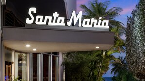 A hotel named "Santa Maria" with a prominent illuminated sign, a glass entrance, and a view of the ocean. - Santa Maria Suites (Key West)