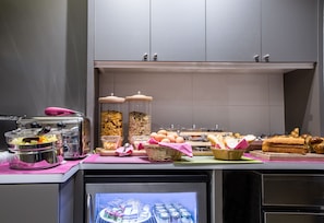 Un buffet proposant une variété de plats, notamment du pain, des œufs et des condiments.