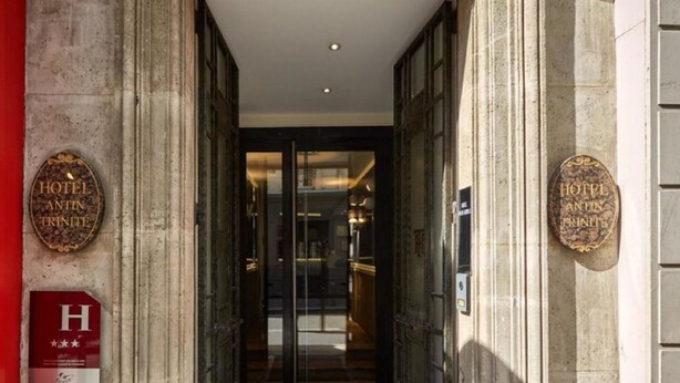 The entrance to Hotel Antin Trinite with a classic architectural design, featuring large stone columns and a glass door leading into the lobby. - Hôtel Antin Trinité (Paris)