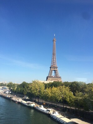Der Eiffelturm mit einem Fluss und Booten im Vordergrund.