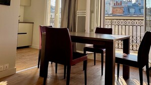 Un espace repas offrant une vue sur le paysage urbain, avec notamment un dôme et une tour.