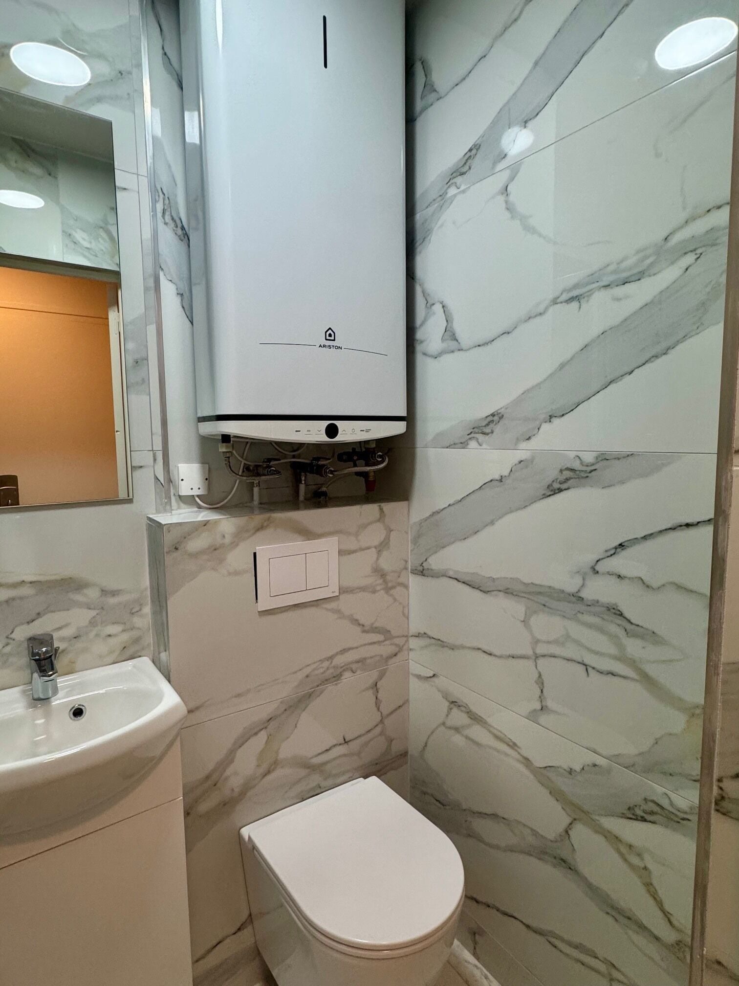 Ein Badezimmer mit Toilette, Waschbecken und einem Wandheizkörper.
