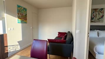 A modern room with a dining table, chairs, a sofa, and a bed.