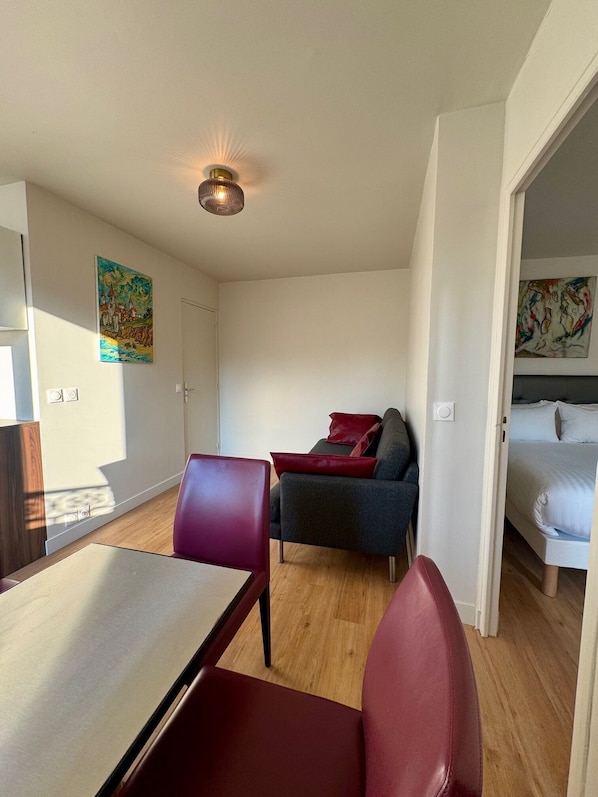 A modern room with a dining table, chairs, a sofa, and a bed. - Villa Montmartre - Nouvellement rénovée (Paris)