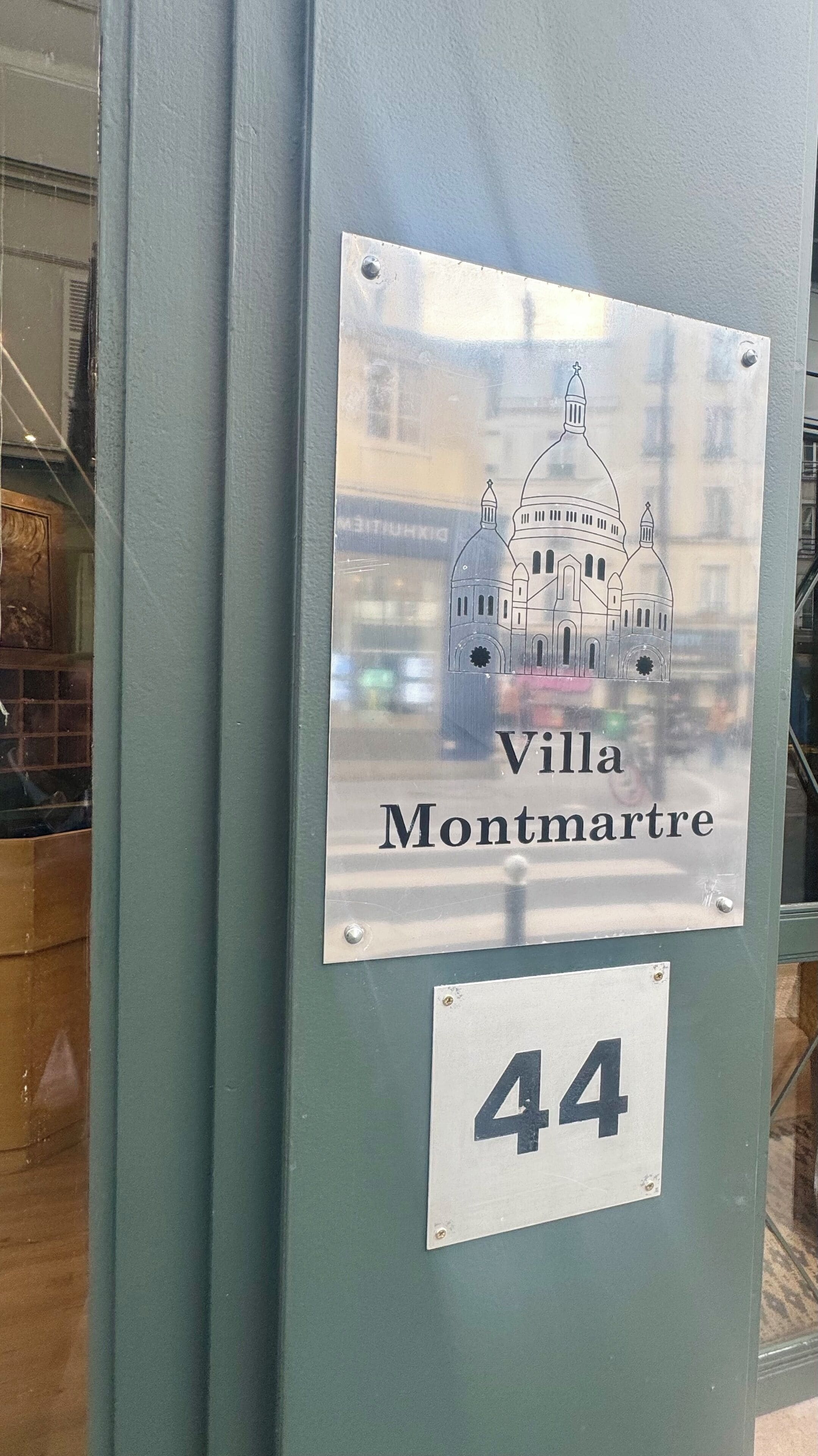 A sign with a building illustration and the text 'Villa Montmartre' and the number '44'.