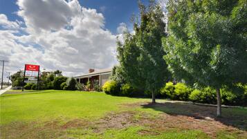 Experience the serene atmosphere of Econ Lodge, surrounded by lush greenery and mature trees.