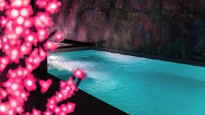 Un spa moderno con una bañera grande y una pantalla mural que muestra un paisaje natural.